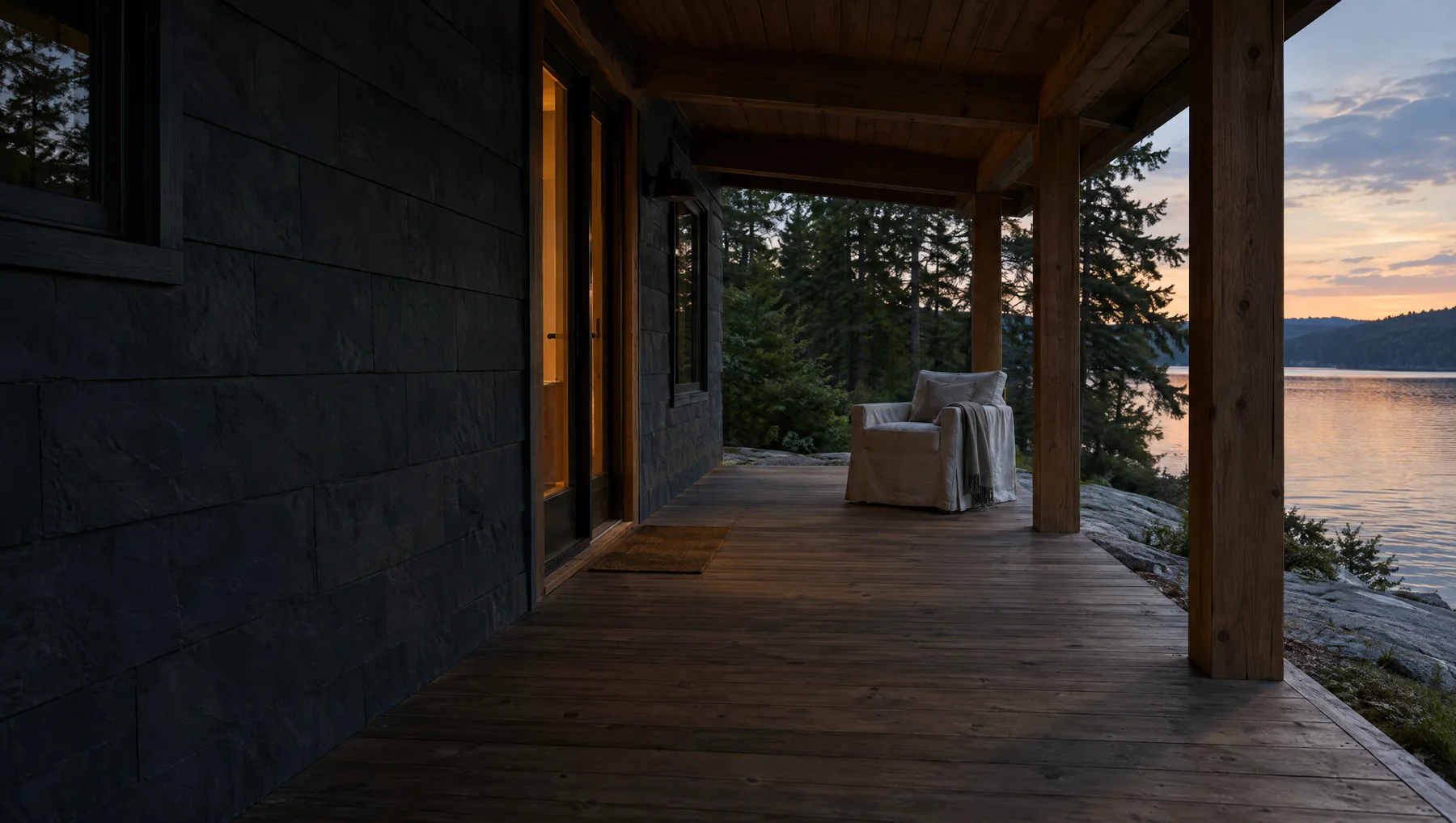 The covered porch at dusk, with warm light spilling from an open door